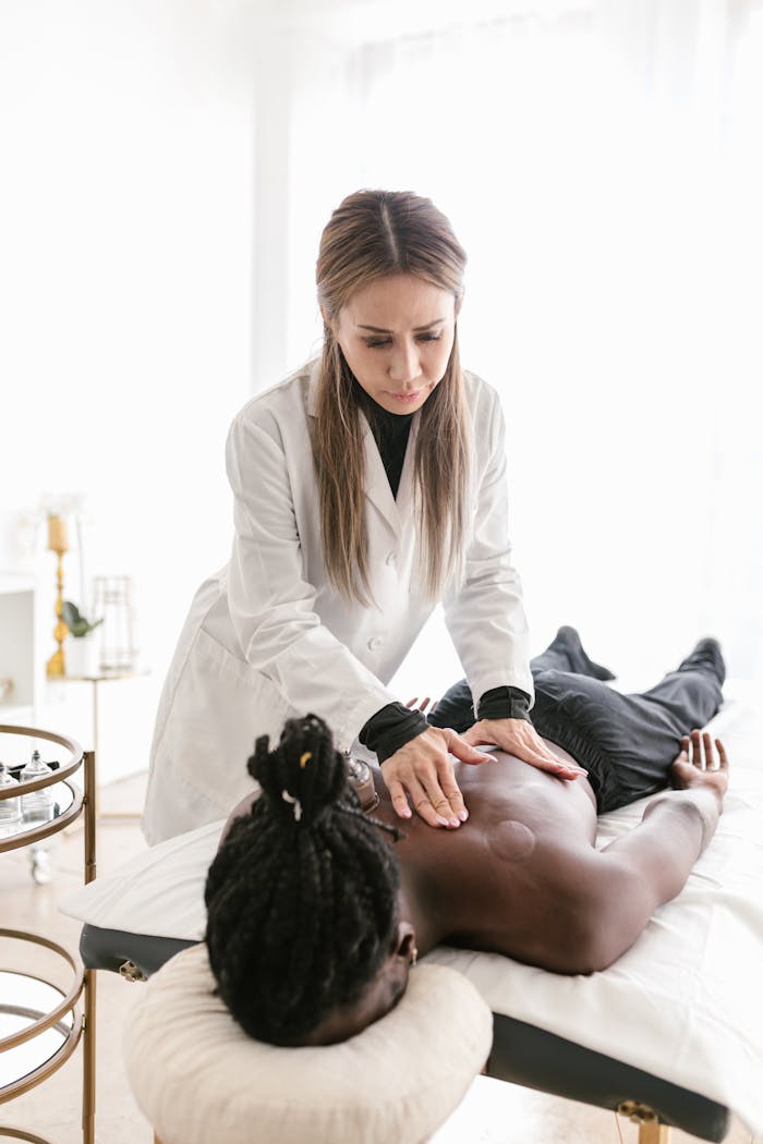 A holistic health practitioner performing body therapy on a patient in a modern wellness clinic.